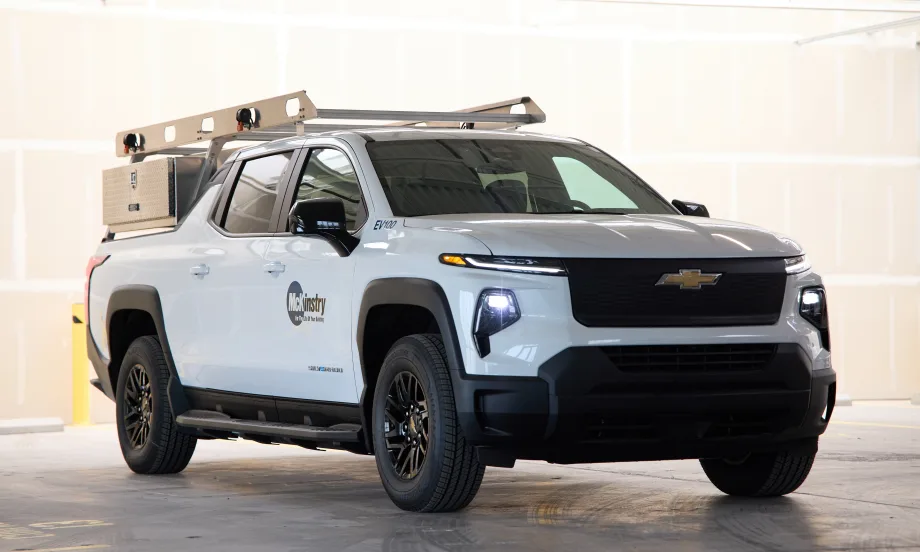 A full photo of a Silverado electric pickup rests in a stone garage with the McKinstry logo on its left side.