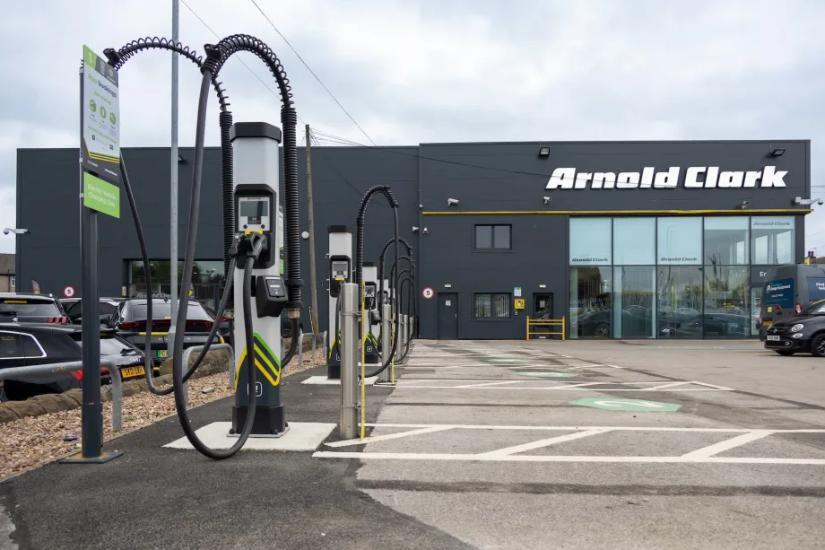 An Arnold Clark black building with an electric charger out front