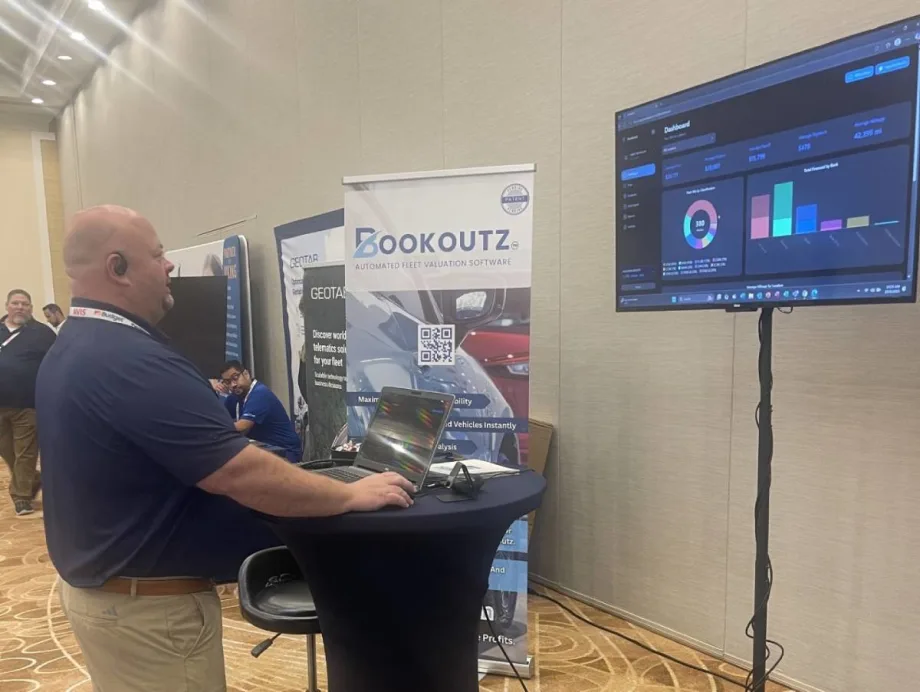 Bookoutz CEO demonstrating program on a laptop computer at a trade show.
