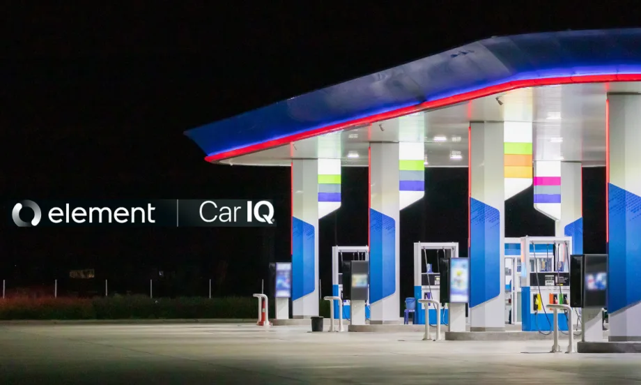 A gas station late at night sits on the right side of a dark photo.