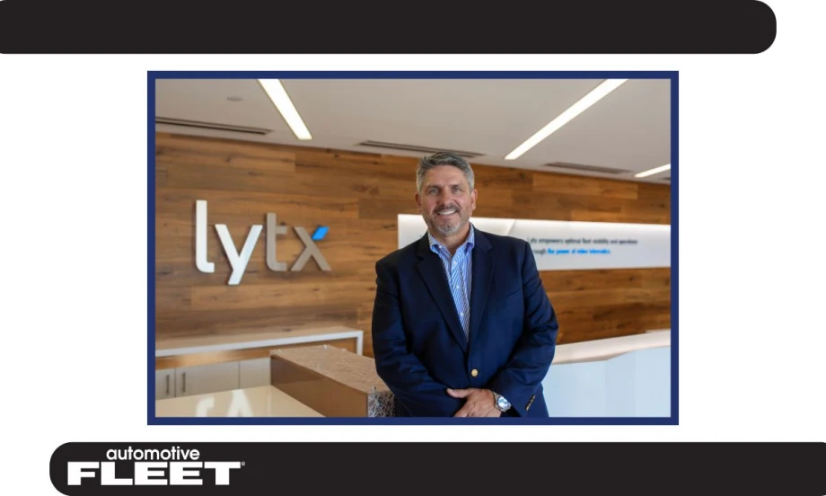 Chris Cabrera, newly appointed CEO of Lytx, stands in the company’s lobby, smiling in front of the Lytx logo.