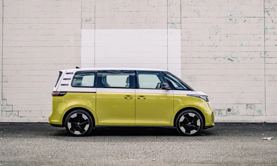 An electric green Volkswagen ID. Buzz parked in front of a white brick wall.