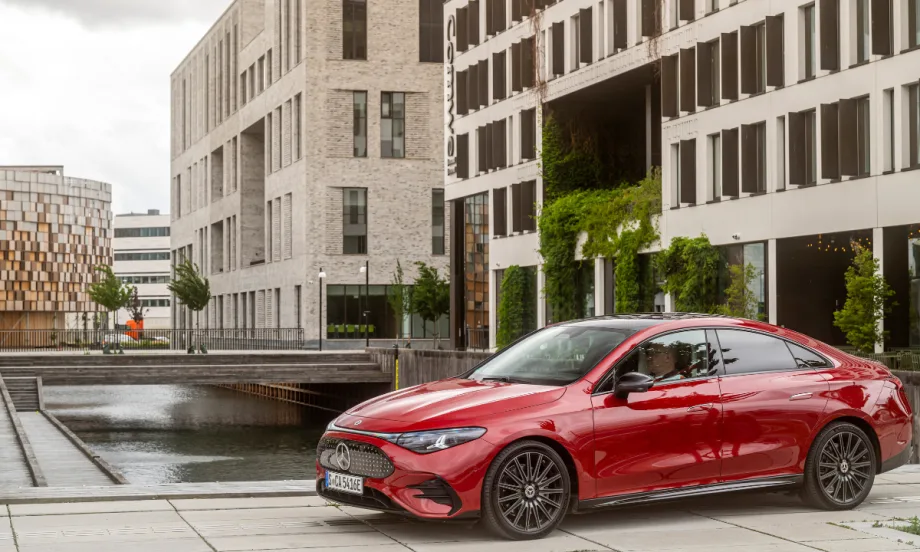 A 2026 electric Mercedes-Benz CLA sits in front of a tan building.