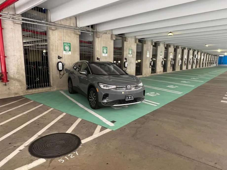 An electric vehicle gets charged along a line of EV chargers at the main airport in Honolulu, Hawaii.