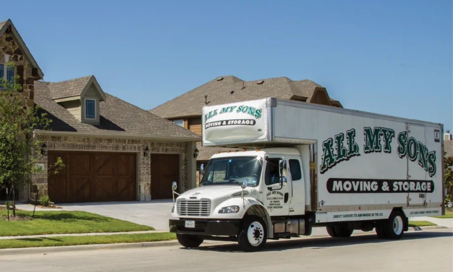 An All My Sons Moving & Storage truck outside a residential home in a neighborhood.