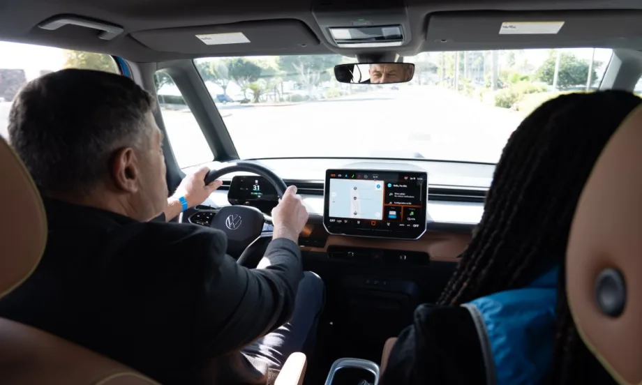 Interior shot of two people test driving a Volkswagen car.