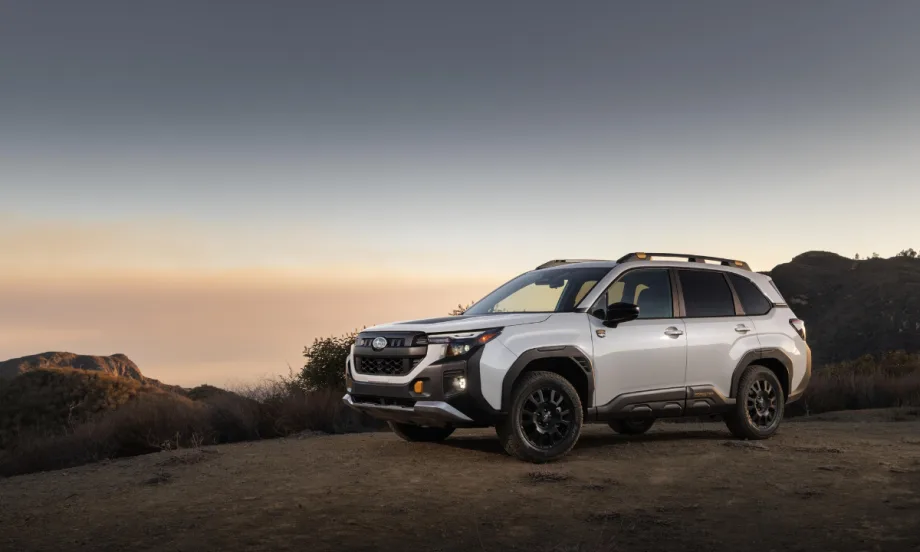 The Subaru Forester Wilderness drives in the desert with a sunset falling behind it.