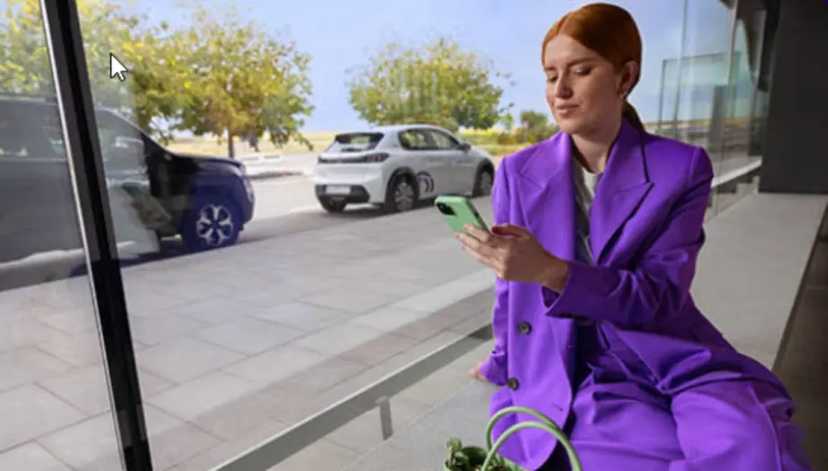 An app user looks at her smartphone near a row of vehicles.