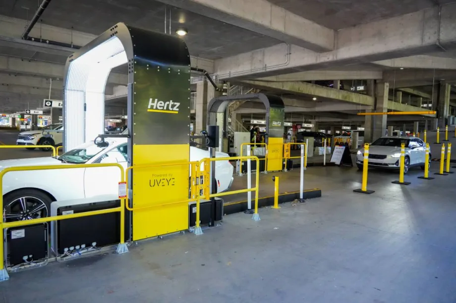 A vehicle inspection arch-style imaging structure that takes photos of rental cars returning to an airport parking deck.