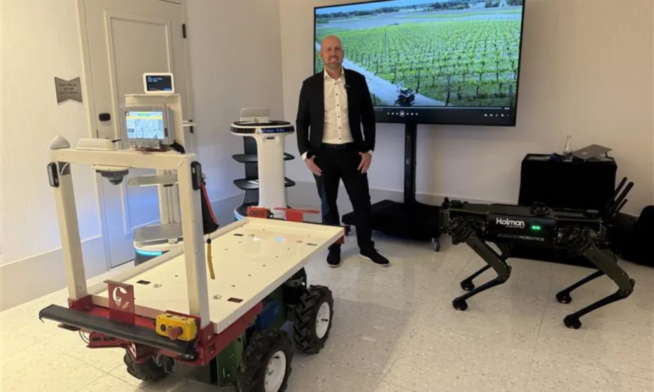 Joe Foster stands next to new Holman robotics managements solution tech.
