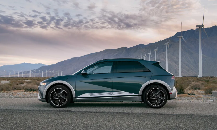 Hyundai IONIQ 5 electric SUV parked near wind turbines, named Best Compact Electric SUV, highlighting fast charging, modern design, and efficiency.