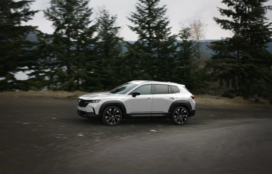 A silver Mazda SUV being driven on a mountain road.