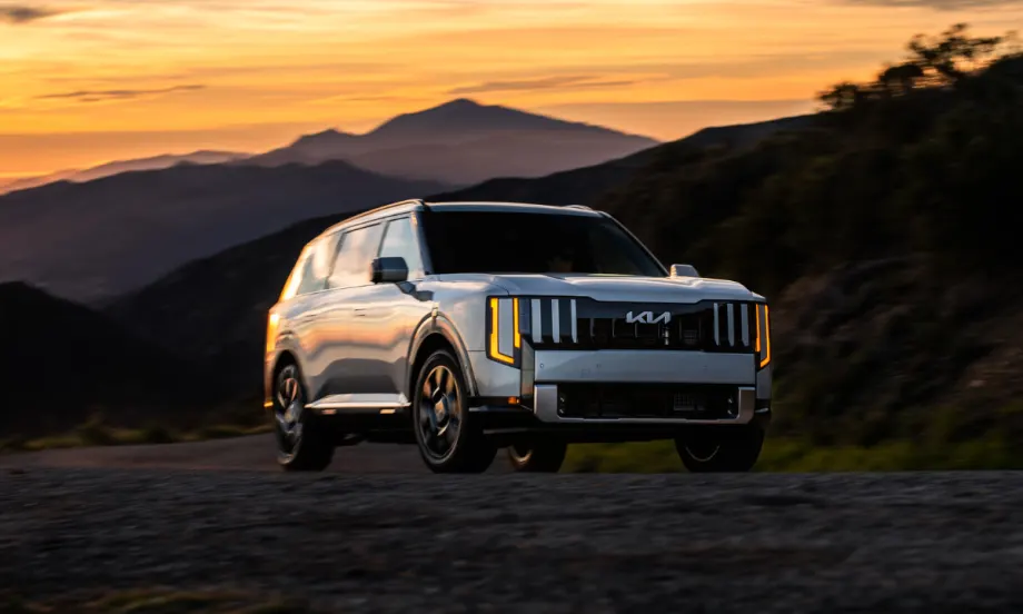 Kia Telluride hybrid SUV driving on a mountain road at sunset, highlighting award-winning electrified models recognized by U.S. News for performance, efficiency, and value.
