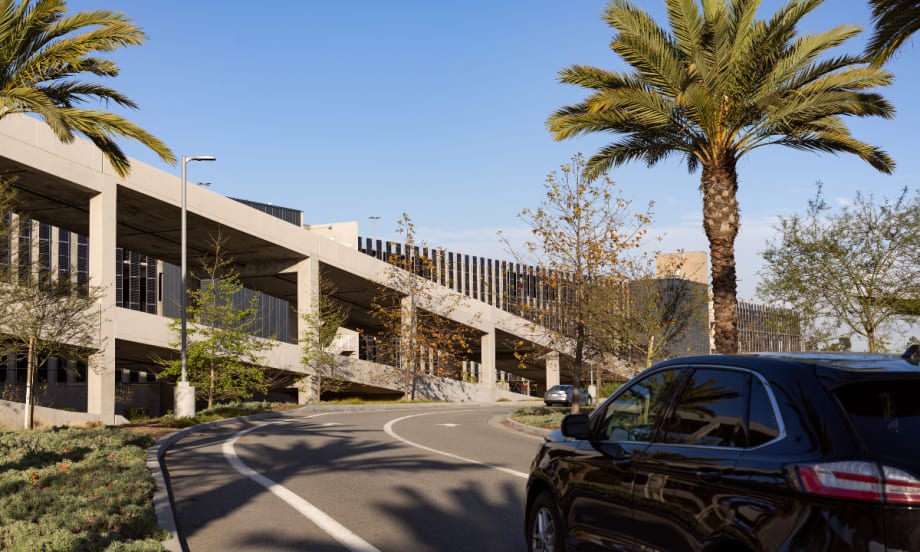 A close up of a roadway leading ot the entrance of the multi-deck LAX Rental Car Center.