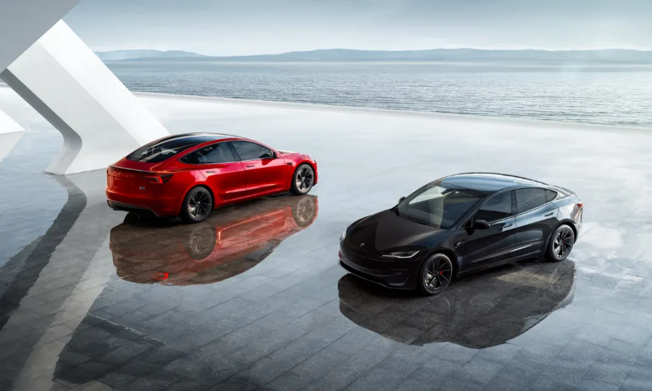 Two Tesla Model Y vehicles parked in front of a horizon. One is red and one is black.