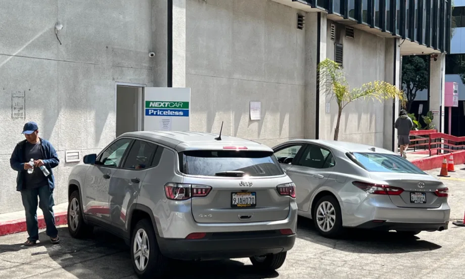 Two rental cars lined up at back entrance of NextCar Priceless rental car outlet near LAX.