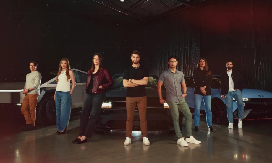 Plug's executive team standing in a V-formation in front of several Tesla electric vehicles.