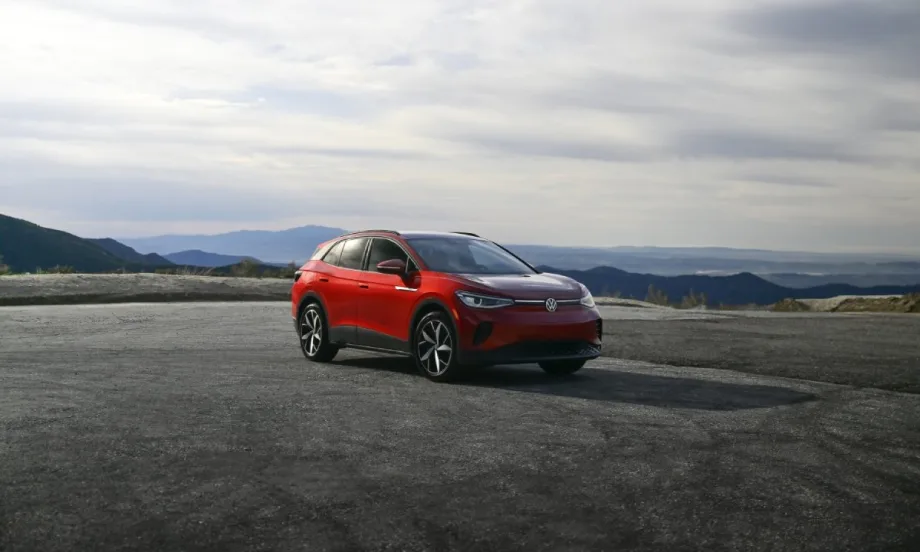 A red Volkswagen ID.4 with mountains on the horizon.