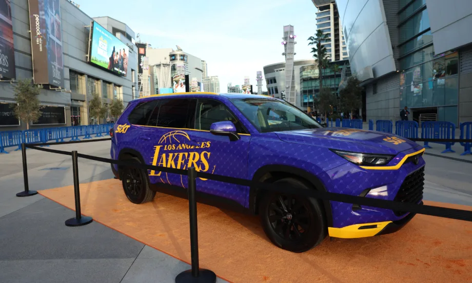 A purple and yellow wrapped Toyota Highlander with the L.A. Lakers logo parked in downtown.