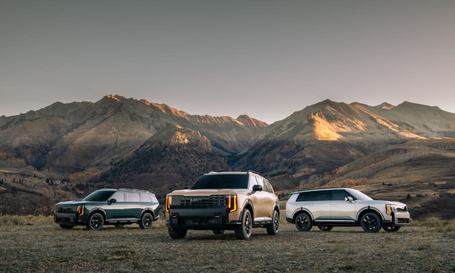 A 2027 Kia Telluride SUV sits on a mountain landscape with two others on each side.