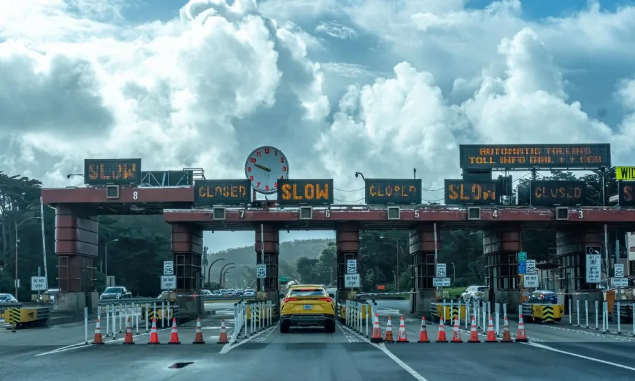 A toll plaza beneath partly sunny cumulonimbus clouds.
