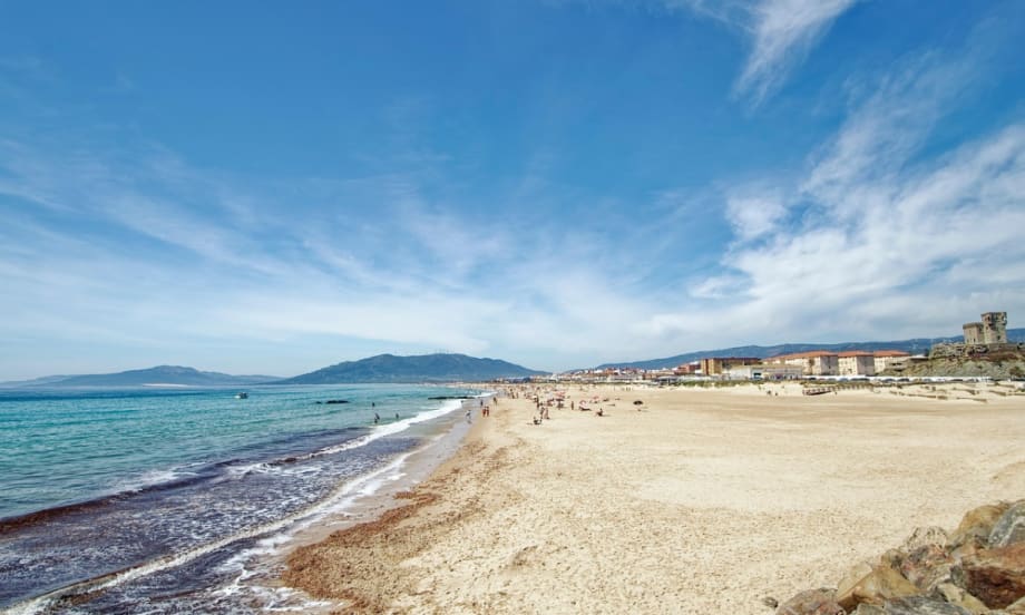 A wide Spanish beach is mostly empty.