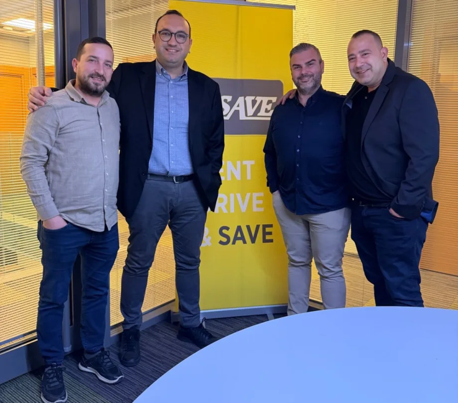 Four U-Save franchisees in front of a U-Save car rental banner.