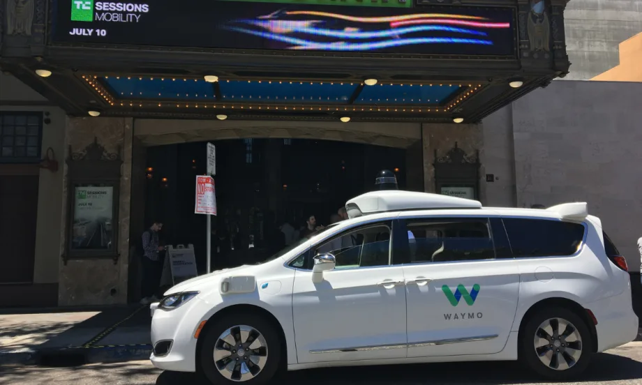 Waymo minivan in front of a theater.
