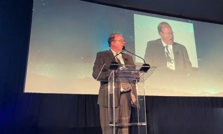 Photo of Mike Antich on stage addressing audience
