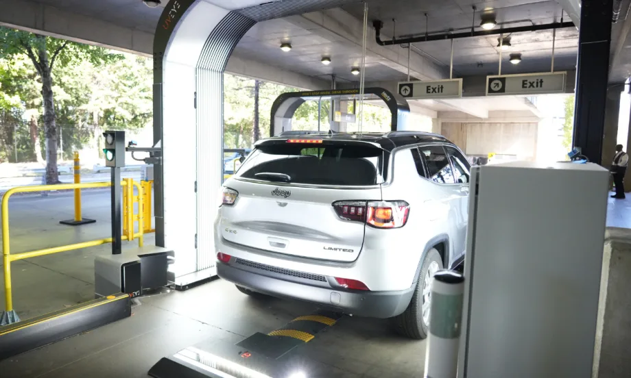 A rental car rolling through a UVeye overhead vehicle inspection terminal.