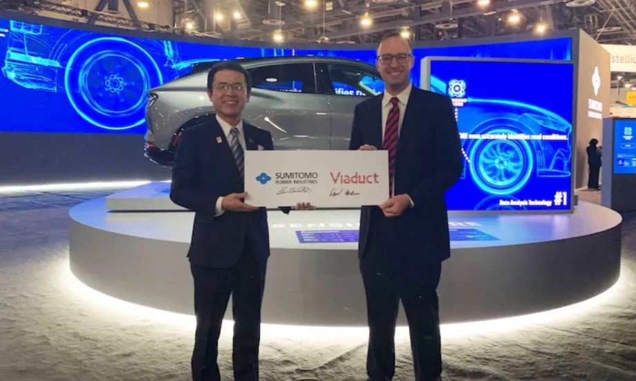 Two people pose with a sign symbolizing Viaduct's partnership with SRI.