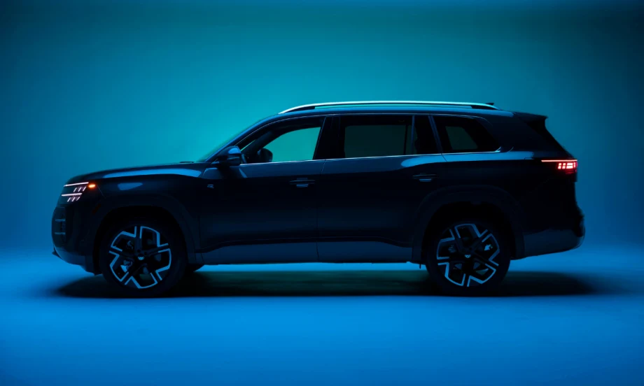 Side profile of a dark Volkswagen Atlas SUV in a studio setting with blue lighting, highlighting updated design and exterior styling.