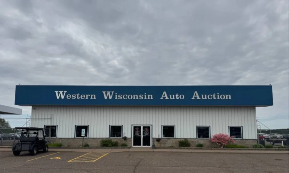 The front of the main building at Western Wisconsin Auto Auction on a cloudy day.